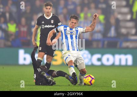 Il capitano della città di Huddersfield Jonathan Hogg è affrontato da Jean Michael seri di Fulham Foto Stock