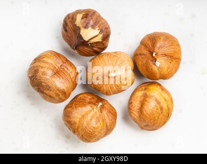 diverse nocciole sgusciate si avvicinano alla piastra in ceramica grigia Foto Stock