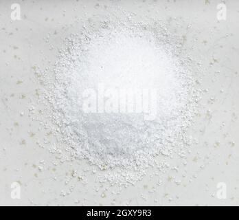 vista dall'alto del cumulo di sostituto dello zucchero - estratto cristallino di pianta di stevia primo piano su piastra di ceramica grigia Foto Stock