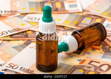 Immagine simbolica per costi elevati di farmaci con bottiglia di farmaco su denaro (banconote da 50 euro). Concetto medico. Foto Stock