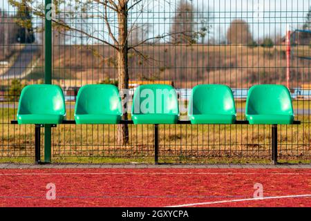 Sedie di plastica vuote nel campo di pallacanestro all'aperto Foto Stock