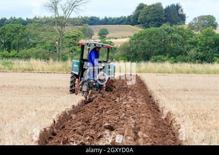 Middleshaw, Scozia - 16 agosto 2020 : trattore Vintage di Fordson che arava con un aratro Ransomes trainato d'epoca Foto Stock