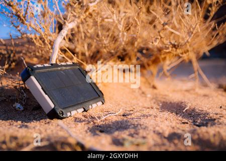Robusto banco di energia con pannello solare che carica l'elettricità nel deserto Foto Stock