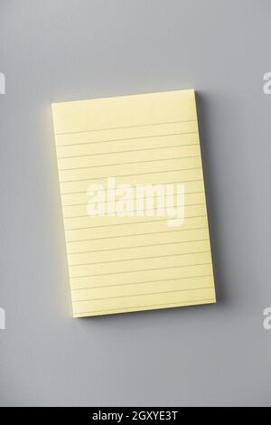Blocco note in carta adesiva vuoto sul tavolo grigio. Vista dall'alto. Foto Stock
