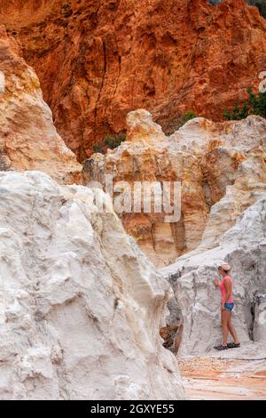 Una femmina esplora i Pinnacoli una combinazione di sabbia bianca e argilla rossa. Le argille di ferro sono salite in cima da acqua che sale in caldo sole dislodgi Foto Stock