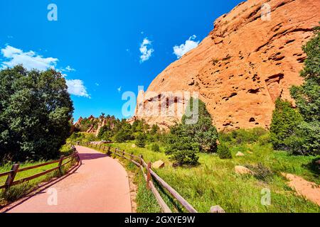 Sentiero lastricato con recinzione attraverso il deserto con grandi colonne di montagna rosse Foto Stock