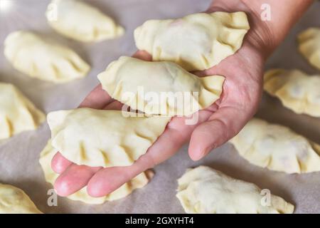 Fare gnocchi ripieni di ciliegia con zucchero, tenendo a mano gnocchi appena fatti Foto Stock