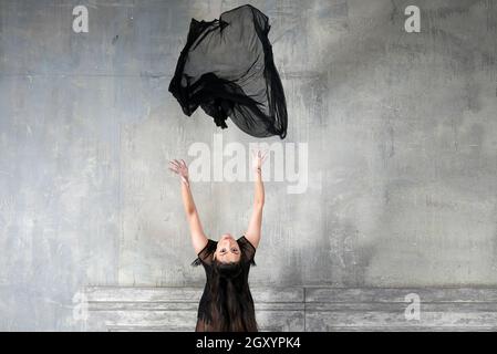 Una ragazza getta un panno nell'aria Foto Stock