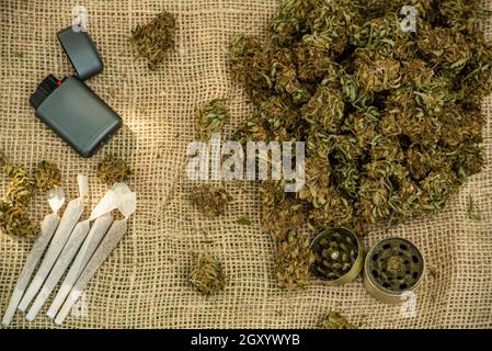 Marijuana con macinacaffè e rotoli articolati e composizione di fiori d'erbaccia Foto Stock