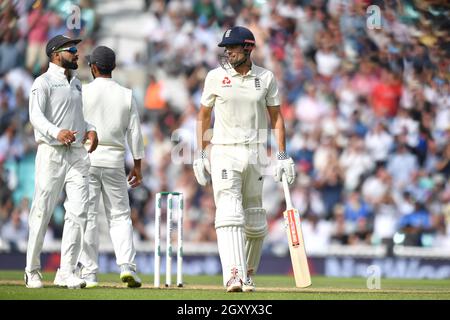 Alastair Cook inglese parla con il capitano indiano Virat Kohli mentre esce dal campo per l'ultima volta dopo aver segnato 147 nella sua finale prova durante la prova alla Kia Oval di Londra. Foto Stock