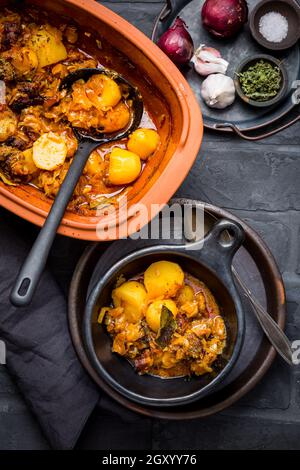 Gulasch fatto in casa con patate e crauti. Manzo e stufato di verdure cucinati in pentola di argilla Foto Stock