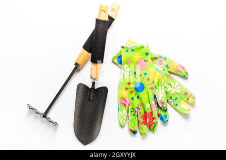 Attrezzi da giardino con guanti da giardino su sfondo bianco. Concetto di giardinaggio. Foto Stock