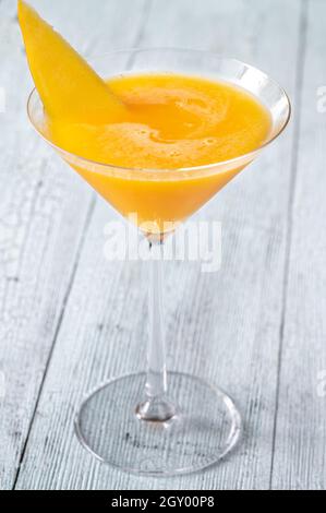 Bicchiere di Apricot Mango cocktail guarnito con fetta di mango fresco Foto Stock