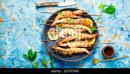 Scampi alla griglia, gamberi arrostiti su uno spiedino. Piatto di pesce alla griglia Foto Stock