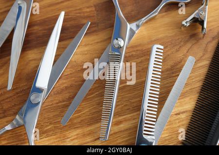 Set di forbici e pettini su piano in legno Foto Stock