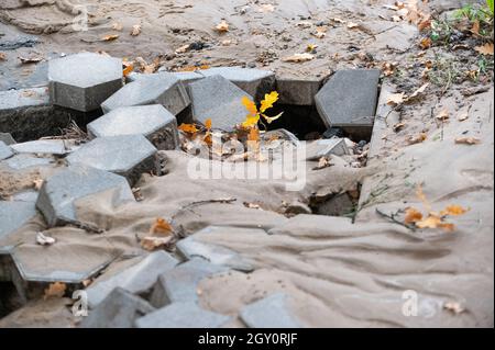 Amburgo, Germania. 06 ottobre 2021. Sabbia e lastre di pietra sospinte sulla strada accanto al cantiere. A causa di una pipa d'acqua scoppiata a Fuhlsbüttler Straße, gli automobilisti nel nord di Amburgo dovranno prepararsi per gli ostacoli nelle prossime due settimane. Le perdite d'acqua hanno lavato fuori la strada nella zona di Ohlsdorfer Friedhof e spinto su l'asfalto, ha detto una portavoce per Hamburg Wasser il mercoledì. Credit: Jonas Walzberg/dpa/Alamy Live News Foto Stock