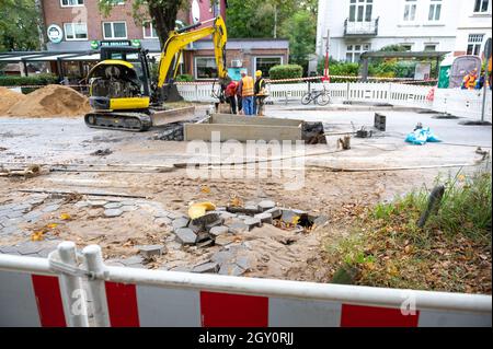 Amburgo, Germania. 06 ottobre 2021. La sabbia e le lastre di pietra sospinte possono essere viste sulla strada accanto al cantiere. A causa di una pipa d'acqua scoppiata a Fuhlsbüttler Straße, gli automobilisti nel nord di Amburgo dovranno prepararsi per gli ostacoli nelle prossime due settimane. Le perdite d'acqua hanno lavato la strada nella zona di Ohlsdorfer Friedhof e spinto su l'asfalto, ha detto una portavoce per Hamburg Wasser. Credit: Jonas Walzberg/dpa/Alamy Live News Foto Stock