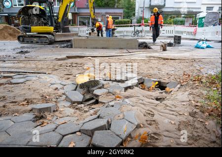 Amburgo, Germania. 06 ottobre 2021. Sabbia e lastre di pietra sospinte sulla strada accanto al cantiere. A causa di una pipa d'acqua scoppiata a Fuhlsbüttler Straße, gli automobilisti nel nord di Amburgo dovranno prepararsi per gli ostacoli nelle prossime due settimane. Le perdite d'acqua hanno lavato fuori la strada nella zona di Ohlsdorfer Friedhof e spinto su l'asfalto, ha detto una portavoce per Hamburg Wasser il mercoledì. Credit: Jonas Walzberg/dpa/Alamy Live News Foto Stock