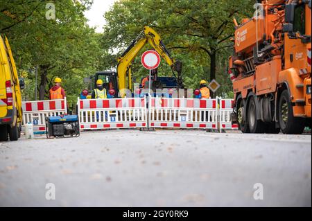 Amburgo, Germania. 06 ottobre 2021. Un escavatore lavora dietro la barriera del cantiere. A causa di una pipa d'acqua scoppiata a Fuhlsbüttler Straße, gli automobilisti nel nord di Amburgo dovranno prepararsi per gli ostacoli nelle prossime due settimane. Le perdite d'acqua hanno lavato fuori la strada nella zona di Ohlsdorfer Friedhof e spinto su l'asfalto, ha detto una portavoce per Hamburg Wasser il mercoledì. Credit: Jonas Walzberg/dpa/Alamy Live News Foto Stock