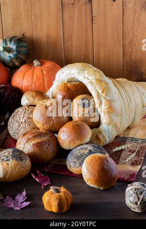 Vista verticale di ciambelle che versano da una cornucopia del pane. Un concetto di Thanksgiving. Foto Stock