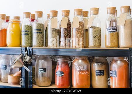 Negozio ecologico senza rifiuti. Bottiglie di vetro, vasetti con erbe e spezie in un negozio di alimentari sostenibile privo di plastica. Alimenti biologici biologici biologici. Shopping in piccole dimensioni Foto Stock