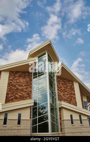 Grande cappella con finestre con una facciata in mattoni durante il giorno Foto Stock