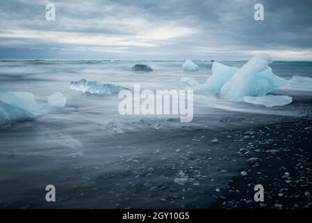 Ghiaccioli e sabbia nera sulla spiaggia di Jokulsarson Diamond, Islanda Foto Stock