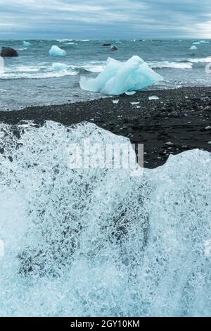 Ghiaccioli e sabbia nera sulla spiaggia di Jokulsarson Diamond, Islanda Foto Stock