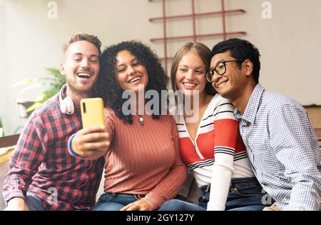 Gruppi di giovani amici che fanno selfie con smartphone - concetto di comunità con amici multiculturali e multietnici divertirsi a videochiamare con gli amici Foto Stock