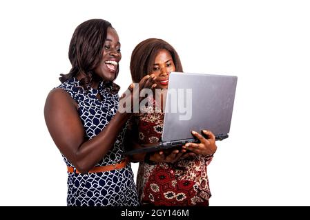 foto di due donne d'affari felici con documenti e laptop in mano in piedi su sfondo bianco facendo una videochiamata Foto Stock