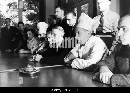 Bei einer Veranstaltung der Reichskochschule folgen die Lehrlinge hoch konzentriert den Erklärungen des Meisterkochs, Deutschland 1930er Jahre. Il altamente concentrato i tirocinanti sono ascoltando le spiegazioni del maestro chef durante un seminario del Reichskochschule, Germania 1930s. Foto Stock