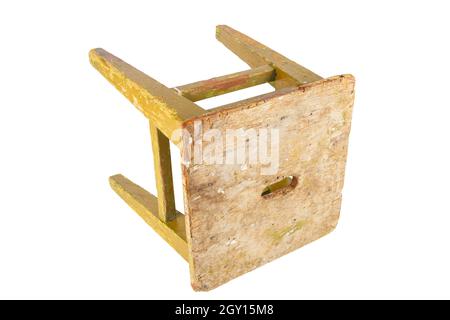 Vecchio sgabello di legno con vernice giallo ocra peeling. Sedia in stile loft isolata su sfondo bianco. Foto Stock
