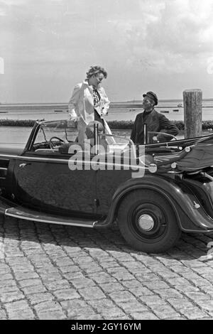 Eine Frau unterhält sich mit einem Parkwächter einer Garage in Norddeich, Deutschland 1930er Jahre. Una donna a parlare con un operatore di parcheggio di un garage di Norddeich, Germania 1930s. Foto Stock