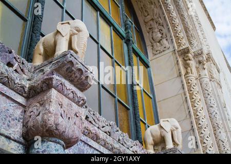 Foto dell'edificio Lansing con statue bianche di elefante poste all'esterno di una finestra arrugginita Foto Stock