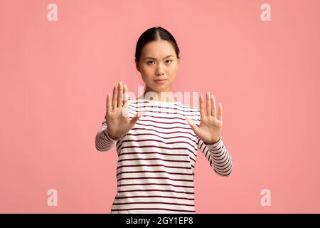 Ritratto di giovane donna asiatica seria che mostra Stop Gesture a Camera Foto Stock