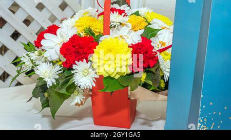 Bel bouquet di fiori festosi con borsa regalo primo piano. Foto Stock