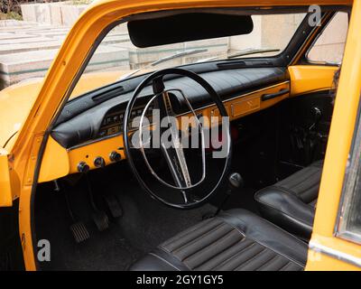 Stekene, Belgio, 25 settembre 2021, l'interno e il volante e cruscotto di un vecchio timer arancione Volvo 122 Foto Stock