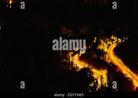 Montagna di notte con auto che percorrano la strada tortuosa Foto Stock