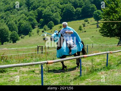 Un uomo a cavallo vestito come cavaliere medievale in una festa rinascimentale. Foto Stock