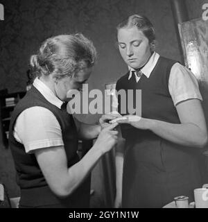 Zwei Frauen bei der Ersten Hilfe bei einem kleinen Haushaltsunfall beim weiblichen Arbeitsdienst in Molkenberg bei Fürstenwalde, Deutschland 1930er Jahre. Due donne in un primo aiuto da un piccolo servizio di pulizie disastro di manodopera femminile gruppo di Molkenberg, Germania 1930s. Foto Stock