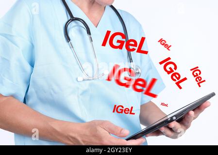 Dottori torse indossa una camicia medica blu, reggendo una tavoletta con i segni del sistema tedesco IGEL Foto Stock
