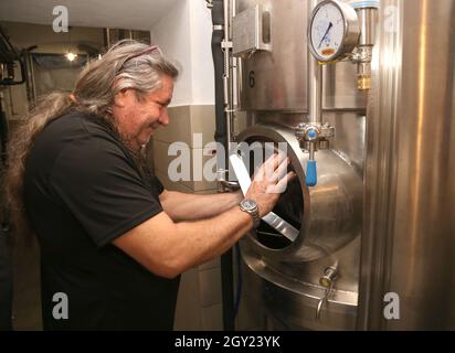 Cracovia. Cracovia. Polonia. Produzione di birra in microbirrificio. bollitore per fermentazione in acciaio inox. Brewmaster chiude il serbatoio. Foto Stock