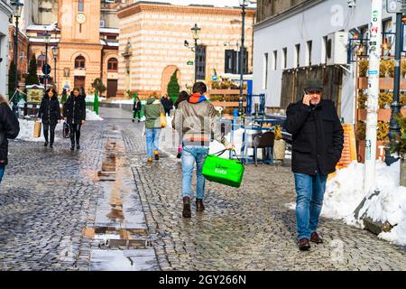 BUCAREST, ROMANIA - 19 gennaio 2021: Una vista posteriore di un giovane maschio che porta 'Uber mangia' sacchetto di consegna di cibo nella strada di Bucarest, Romania Foto Stock