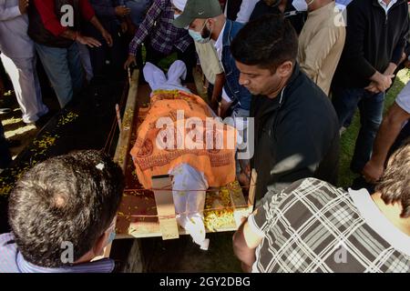 Srinagar, India. 06 ottobre 2021. (NOTA DEI REDATTORI: Immagine raffigura la morte) i parenti portano il corpo morto di Makhan Lal Bindroo, un uomo d'affari Indù pandit e proprietario di una farmacia, durante la sua cremazione a Srinagar. Bindroo, un indù Kashmiri e altri due uomini sono stati uccisi da pistoleri sconosciuti sospettati di essere militanti in attacchi separati il martedì sera. Credit: SOPA Images Limited/Alamy Live News Foto Stock