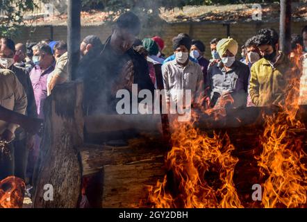 Srinagar, India. 06 ottobre 2021. Un parente prega vicino alla pira bruciante di Makhan Lal Bindroo, un uomo d'affari Indù pandit e proprietario di una farmacia, durante la sua cremazione a Srinagar.Bindroo, un indù Kashmiri e altri due uomini sono stati uccisi da sconosciuti pistoleri sospettati di essere militanti in attacchi separati martedì sera. Credit: SOPA Images Limited/Alamy Live News Foto Stock