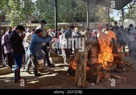 Srinagar, India. 06 ottobre 2021. Parenti e amici eseguono gli ultimi riti vicino alla pira bruciante di Makhan Lal Bindroo, un uomo d'affari Indù pandit e proprietario di una farmacia, durante la sua cremazione a Srinagar. Bindroo, un indù Kashmiri e altri due uomini sono stati uccisi da pistoleri sconosciuti sospettati di essere militanti in attacchi separati il martedì sera. Credit: SOPA Images Limited/Alamy Live News Foto Stock
