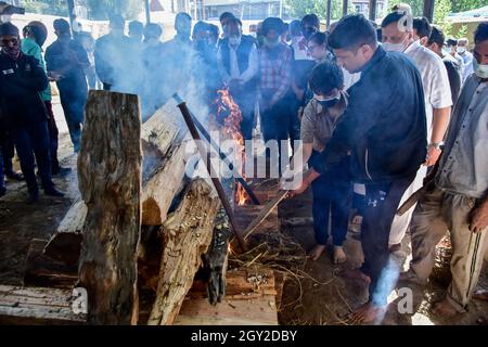 Srinagar, India. 06 ottobre 2021. I parenti eseguono gli ultimi riti vicino alla pira bruciante di Makhan Lal Bindroo, un uomo d'affari Indù pandit e proprietario di una farmacia, durante la sua cremazione a Srinagar. Bindroo, un indù Kashmiri e altri due uomini sono stati uccisi da pistoleri sconosciuti sospettati di essere militanti in attacchi separati il martedì sera. Credit: SOPA Images Limited/Alamy Live News Foto Stock