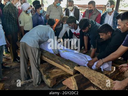 Srinagar, India. 06 ottobre 2021. (NOTA DEI REDATTORI: Immagine raffigura la morte) i parenti portano il corpo morto di Makhan Lal Bindroo, un uomo d'affari Indù pandit e proprietario di una farmacia, durante la sua cremazione a Srinagar. Bindroo, un indù Kashmiri e altri due uomini sono stati uccisi da pistoleri sconosciuti sospettati di essere militanti in attacchi separati il martedì sera. Credit: SOPA Images Limited/Alamy Live News Foto Stock