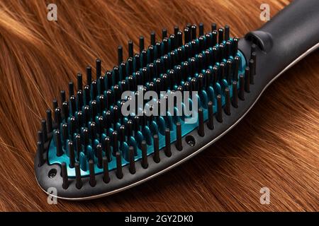 Spazzola elettrica per lisciare i capelli rossi Foto stock - Alamy