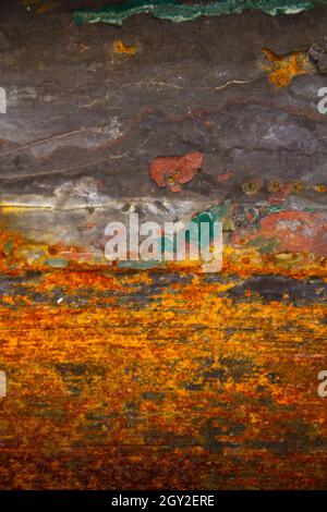 Muro di antiquariato arrugginito in un gradiente di grigio ad arancio a sfondo rosso scuro Foto Stock